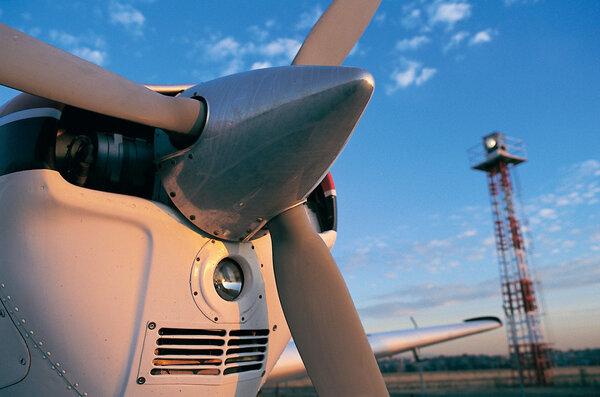 Пропеллер самолета со световой башней на закате
