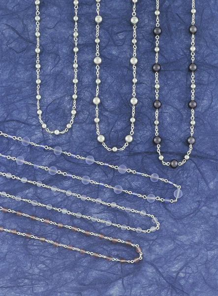 Silver necklaces over a blue background — Stock Photo, Image