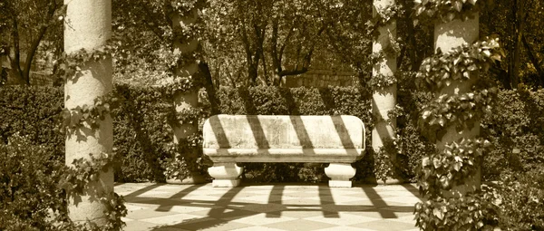 Panchina di pietra in un parco. Tono seppia — Foto Stock