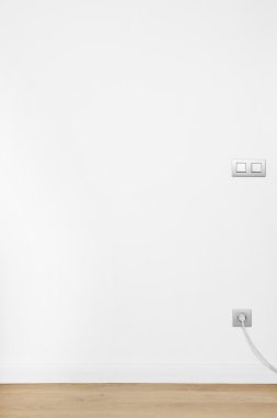 beyaz duvar ahşap zemin ve soket