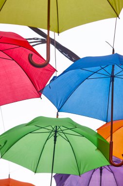 Beyaz bir gökyüzünün altında renkli şemsiyeler. Çok renkli bir arka plan. Dekoratif 