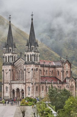 Covadonga 'daki kırmızı taş bazilika ve dağlar. Asturias, İspanya
