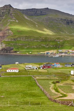 Yeşil Faroe adaları kıyı köyü manzaralı. Famjin, Suduroy.