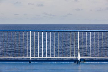 Okyanus ve gökyüzü arkaplanlı tırabzan güvertesi. Tatil seyahati