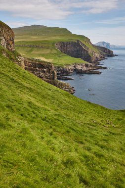 Faroe adalarındaki Mykines kayalıkları ve deniz feneri. Yürüyüş noktası. Danimarka