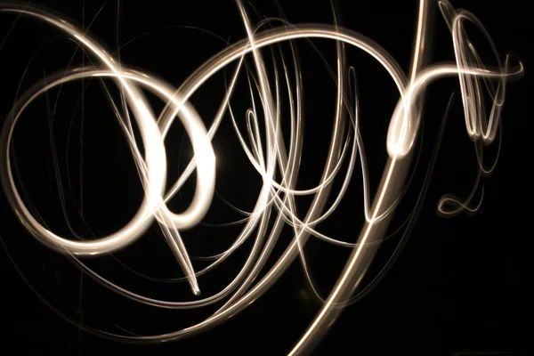 Abstract glowing neon light curves in gold — Stock Photo, Image