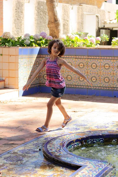Маленькая девочка улыбается и играет на открытом воздухе — стоковое фото