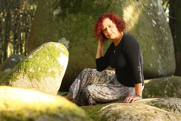 Mujer pelirroja de pie al aire libre en un hermoso bosque verde Fotos de stock libres de derechos