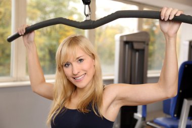 bir spor salonunda çekici sarışın kadın halter
