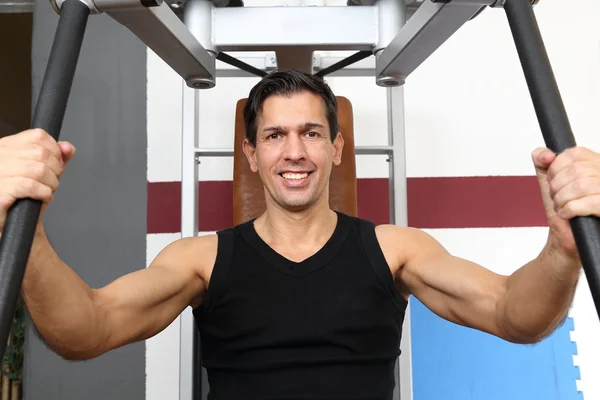 Hombre guapo haciendo ejercicio en un gimnasio — Foto de Stock