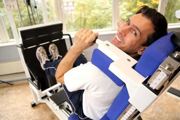 Hombre guapo haciendo ejercicio en un gimnasio — Foto de Stock