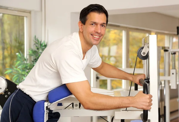 Hombre guapo haciendo ejercicio en un gimnasio — Foto de Stock