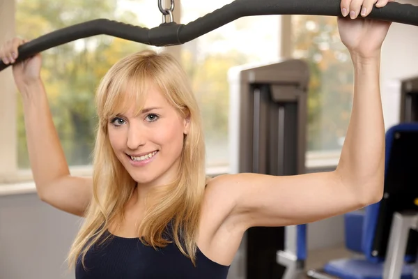 Attractive blonde woman weightlifting in a gym — Stock Photo, Image