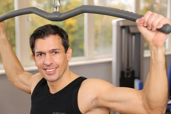 Hombre guapo haciendo ejercicio en un gimnasio — Foto de Stock