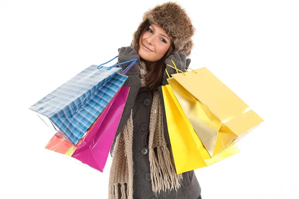 Mujer en ropa de invierno con regalos y bolsas de compras sonriendo — Foto de Stock