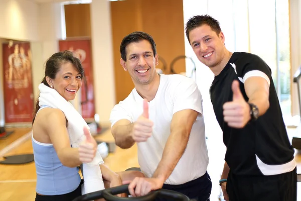 Trois amis dans le gymnase donnant pouces vers le haut — Photo