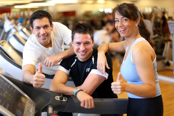 Gruppe von drei Freunden auf Laufband gibt Daumen hoch — Stockfoto