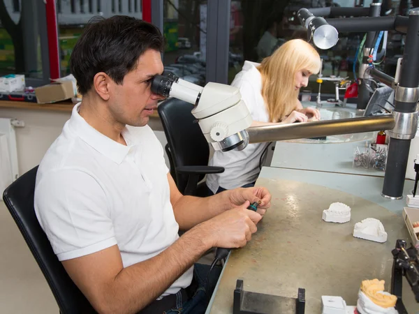 Dental technician polishing gold tooth — Stock Photo, Image