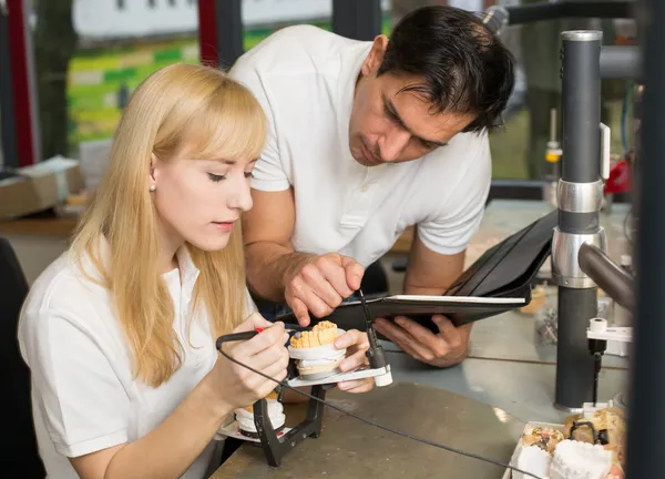 Instructeur onderwijs een leerling in tandheelkundige lab — Stockfoto