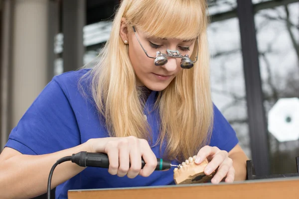 Technicien dentaire avec loupes chirurgicales polissage de la dent d'or — Photo