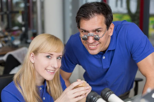 Técnico dentário mostrando uma prótese para um colega — Fotografia de Stock