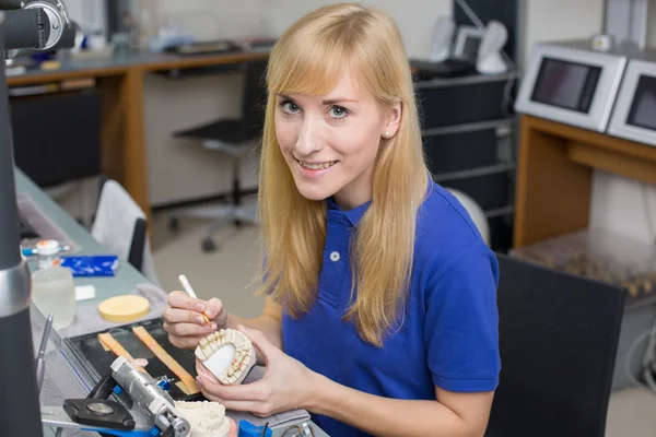 Dental lab technician applying porcelain to dentition mold — Stock Photo, Image