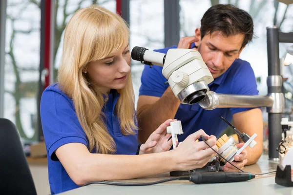 Dental technicians working on mold under a microscope — Stock Photo, Image