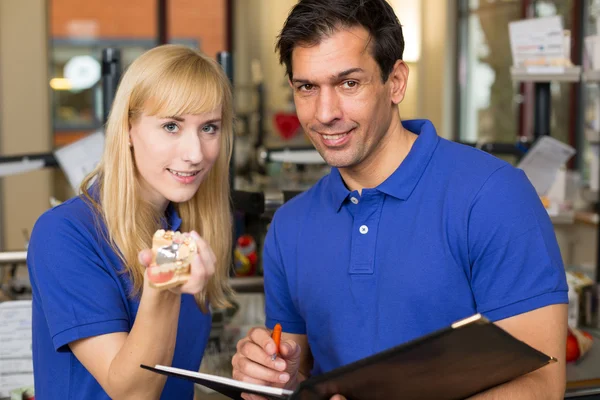 Apprentice and dental technician look at prosthesis — Stock Photo, Image