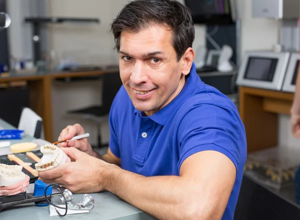 Técnico de laboratório dentário aplicando porcelana para moldar — Fotografia de Stock