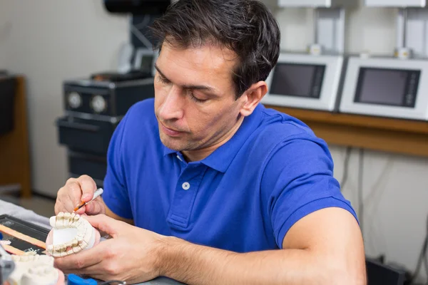 Técnico de laboratório dentário aplicando porcelana para moldar — Fotografia de Stock