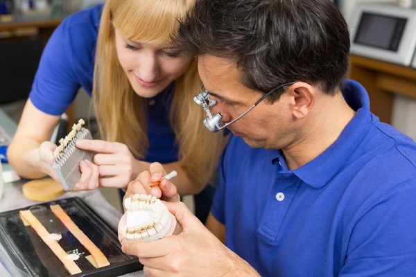 Dois técnicos odontológicos escolhendo a cor certa para porcos dentários — Fotografia de Stock