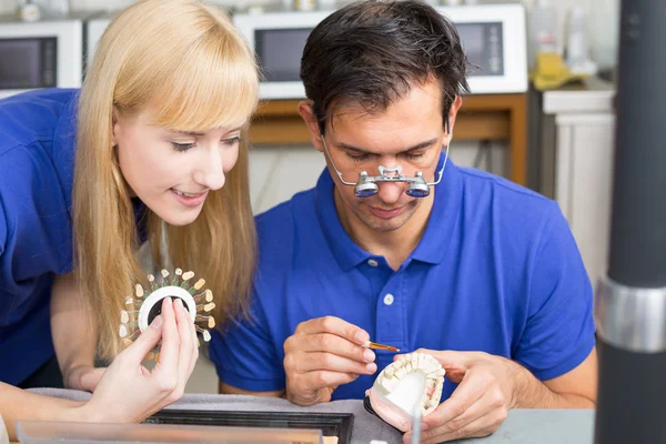 Twee tandtechnici kiezen van de juiste kleur voor tandheelkundige porc — Stockfoto