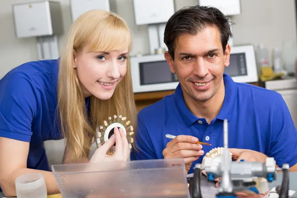 Zwei Zahntechniker wählen die richtige Farbe für Zahnschwein — Stockfoto