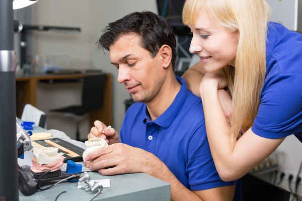 Mujer viendo técnico dental aplicando porcelana —  Fotos de Stock