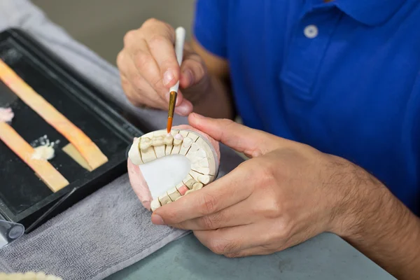 Fecho do técnico odontológico aplicando porcelana — Fotografia de Stock