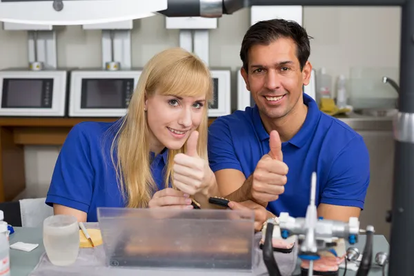 Dois técnicos dentários mostrando polegares para cima — Fotografia de Stock