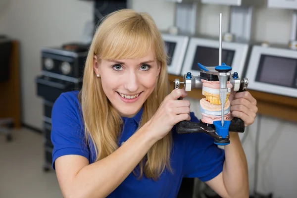 Smiling dental technician with articulator — Stock Photo, Image