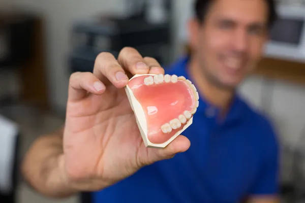 Técnico dentário apresentando prótese dentária — Fotografia de Stock