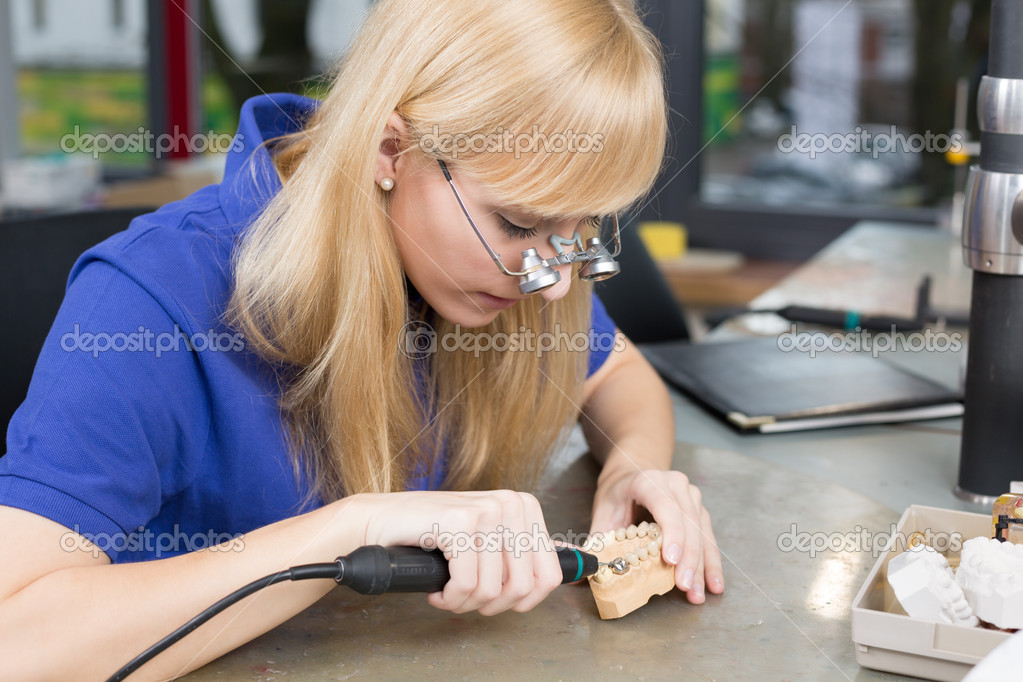 Dental technician with surgical loupes polishing gold tooth — Stock Photo © Ikonoklast 18766597