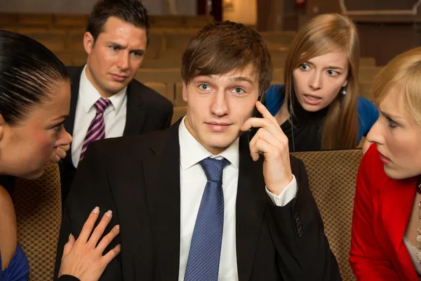 Man in het publiek vervelend anderen met een mobiele telefoon — Stockfoto