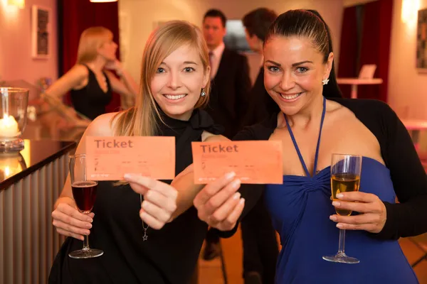 Dos mujeres presentando entradas de cine o teatro — Foto de Stock