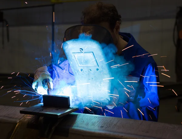 Работник со сварочным шлемом сваривает сталь — стоковое фото