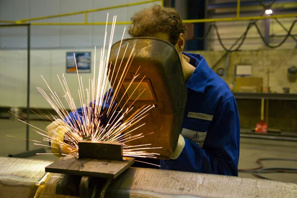 Arbetare med svetshjälm svetsar stål — Stockfoto