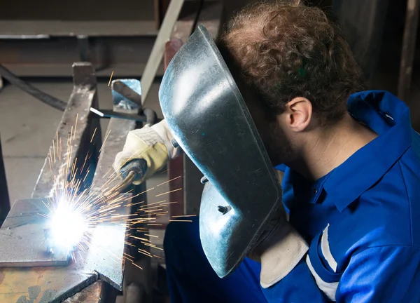 Mann schweißt Stahl und verursacht viele Funken — Stockfoto