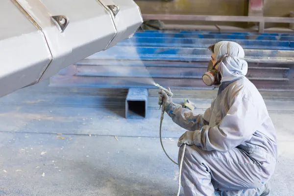 Vehicle painter spraying color on construction bucket — Stock Photo, Image