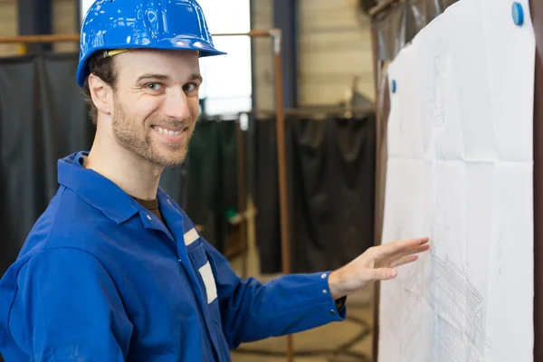 Construction looking at building plan — Stock Photo, Image