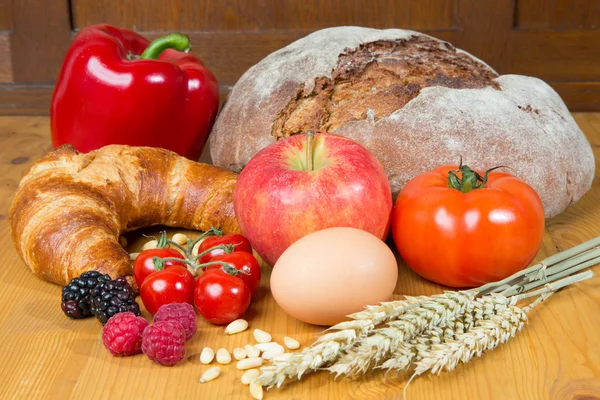 Kitchen table with a lot of food like bread and vegetables — Stock Photo, Image