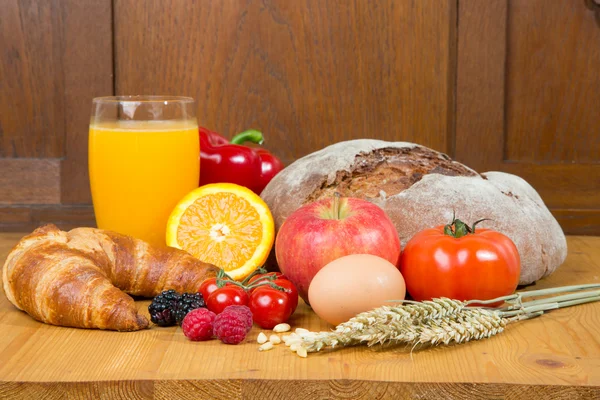 Mesa de la cocina con una gran cantidad de alimentos como pan y verduras —  Fotos de Stock