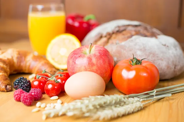 Table de cuisine avec beaucoup d'aliments comme le pain et les légumes — Photo