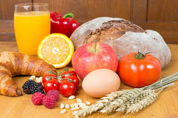 Mesa de la cocina con una gran cantidad de alimentos como pan y verduras — Foto de Stock